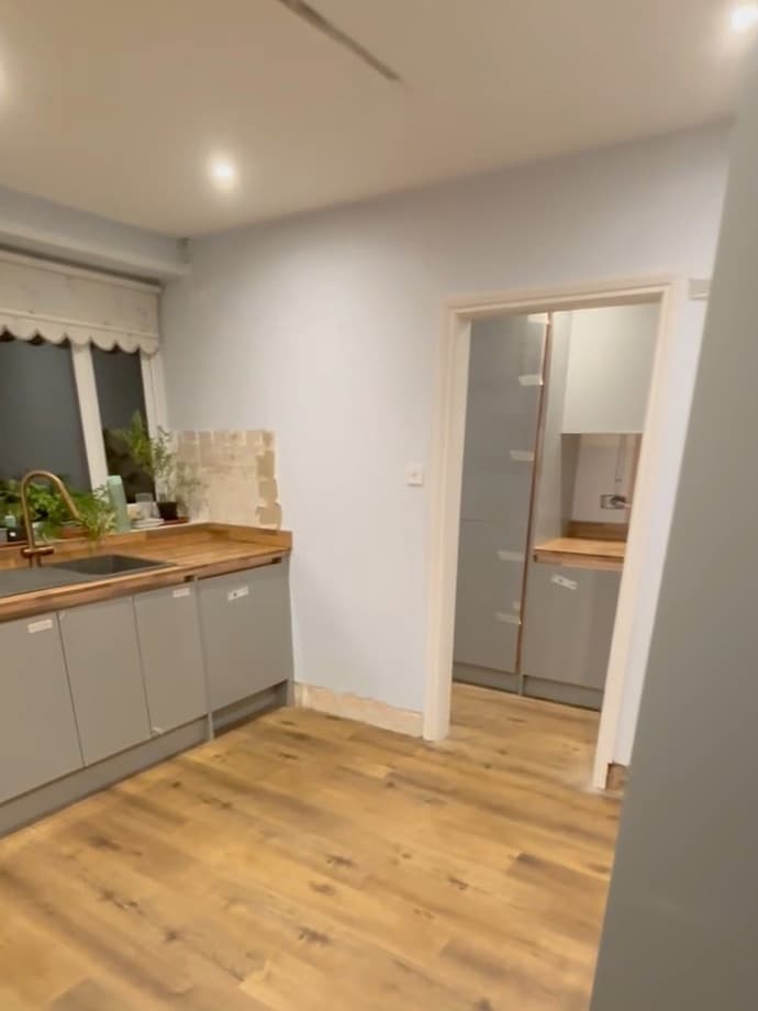 The finished room: solid timber worktop, fitted units, and the new floor running out through the doorway.